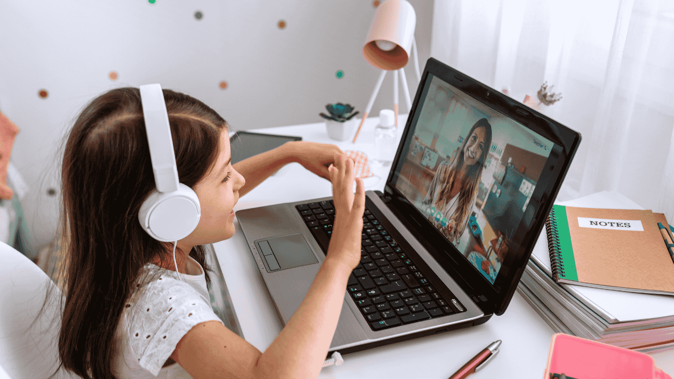 A little girl attending online class and interacting with teacher